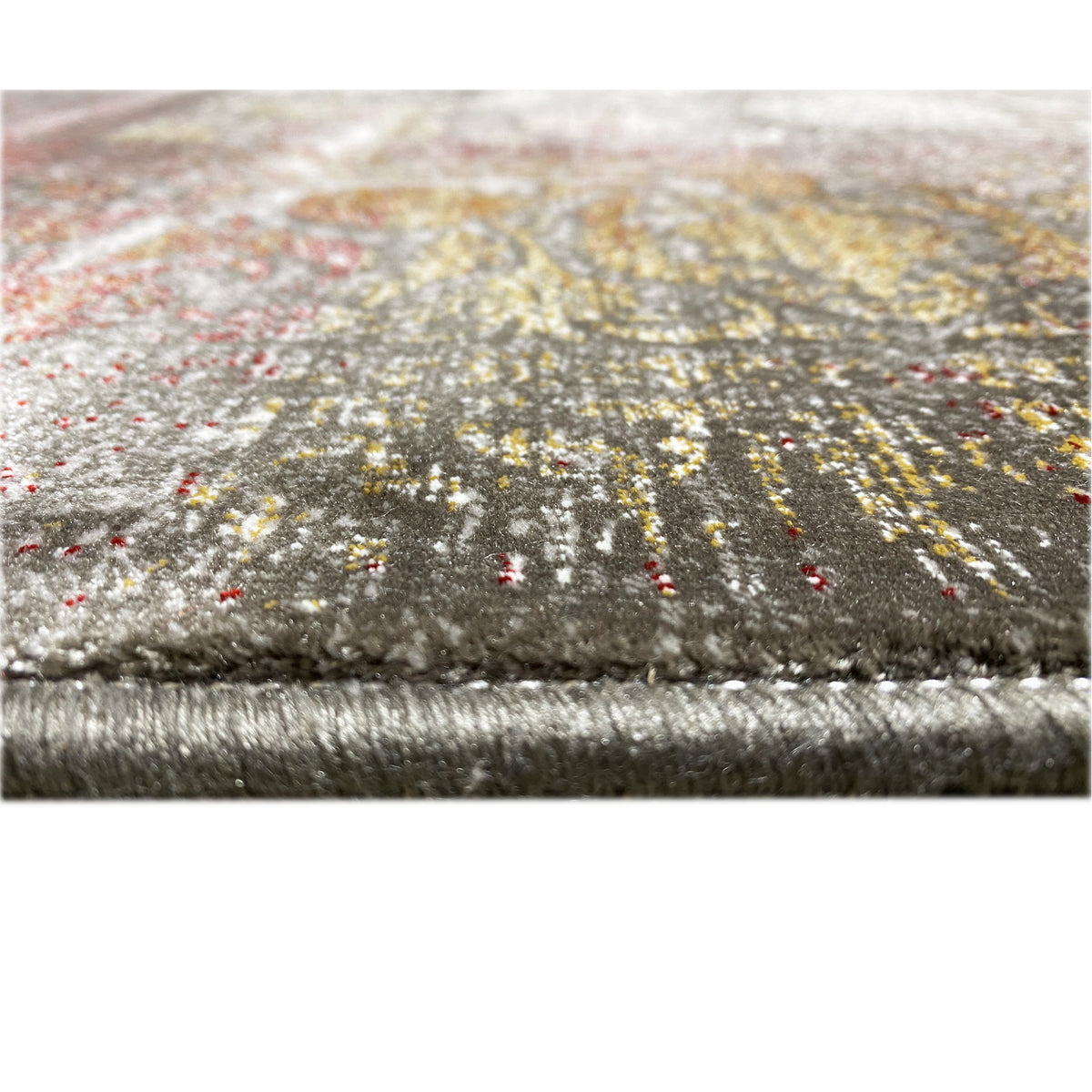 Teppich-Detail am Rand: Fransen, silbrig-graues Floralmuster mit goldbraunen Sprenkeln
