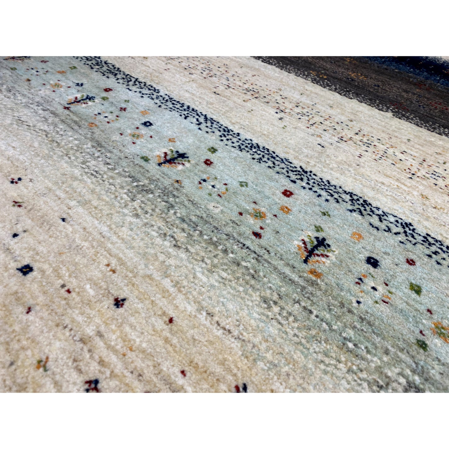 Nahaufnahme: Gabbeh-Teppich mit feinen Punkt- und Schmuckmotiven in Beige und Blau