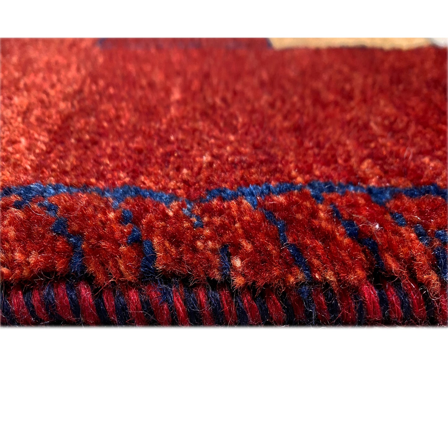 Roter Gabbeh-Teppich-Läufer mit Fransen und blauem Besatz am Rand.