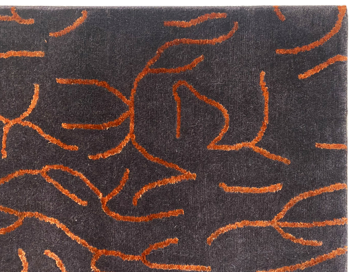 Nahansicht Design-Teppich: dunkelgrauer Flor mit orangefarbenen abstrakten Linien