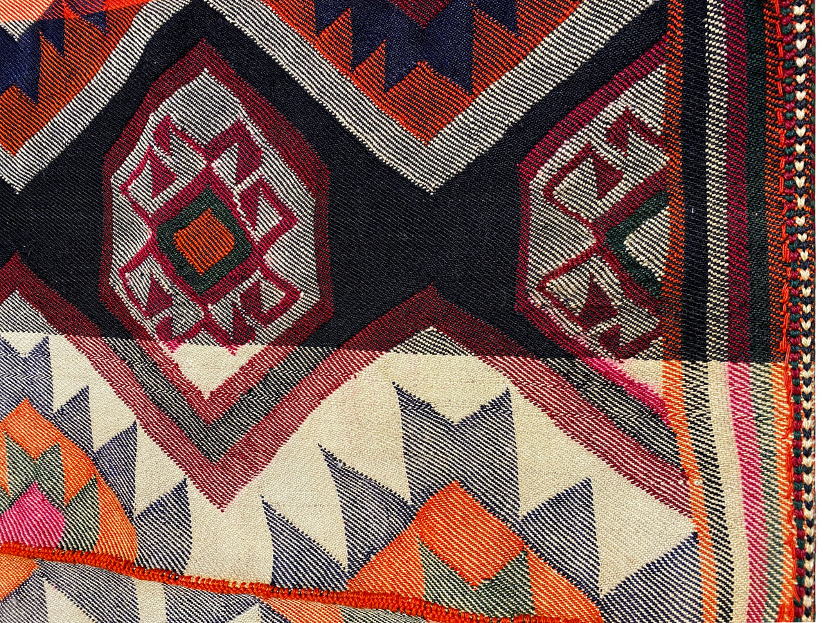 Jajim-Teppich Detail: Rautenornament und Zickzack am Rand in Rot, Schwarz und Creme