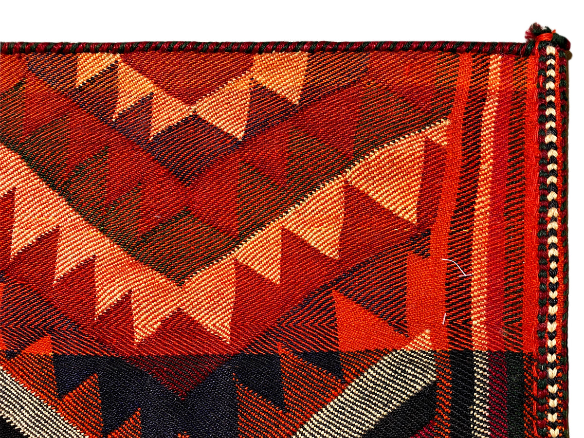 Jajim-Teppich Nahaufnahme: Dreiecke und Zickzack in Orange, Rot, Schwarz und Creme