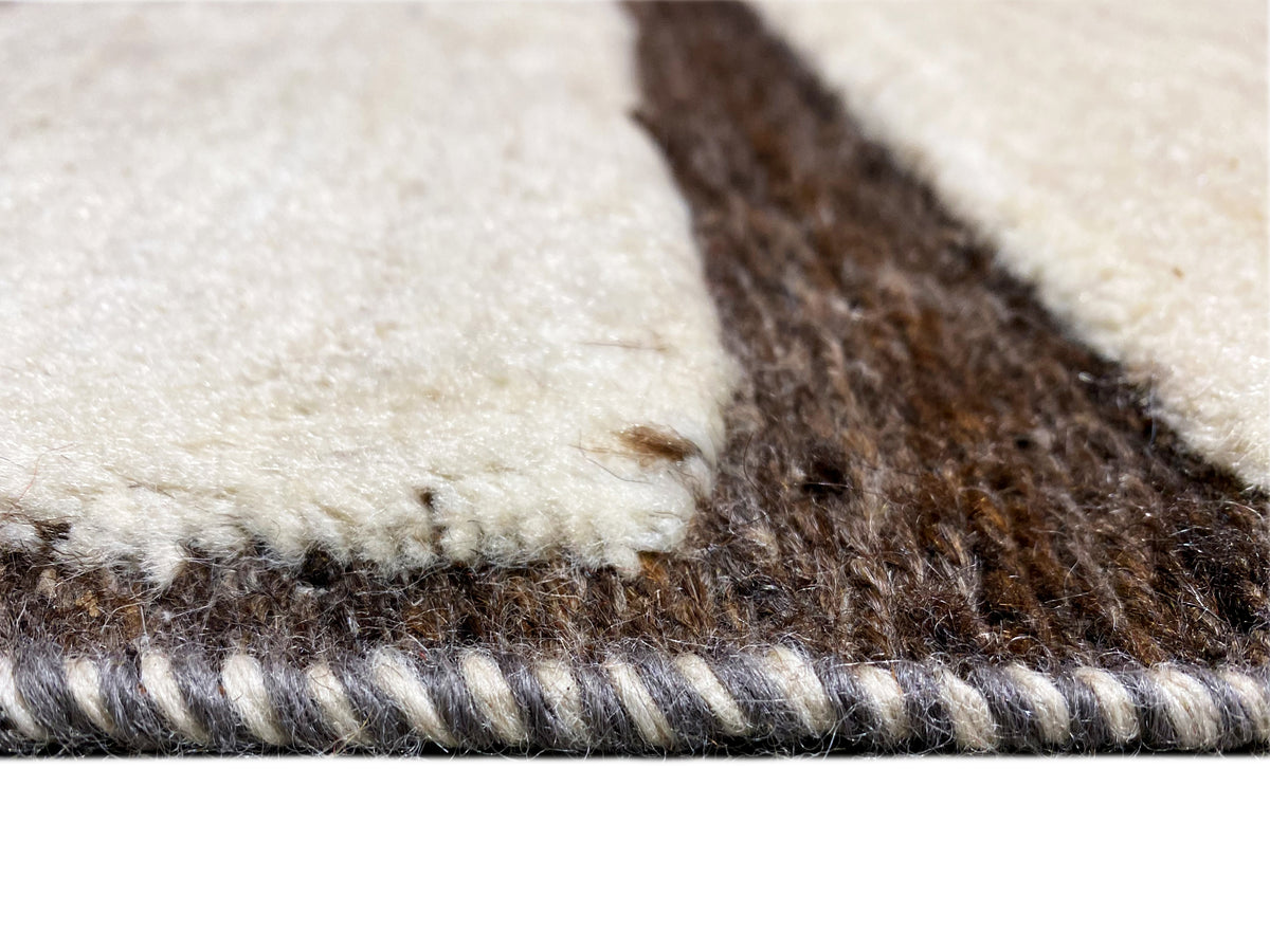 Detail des Teppichflors: creme und braune Fasern, sichtbare Webkante