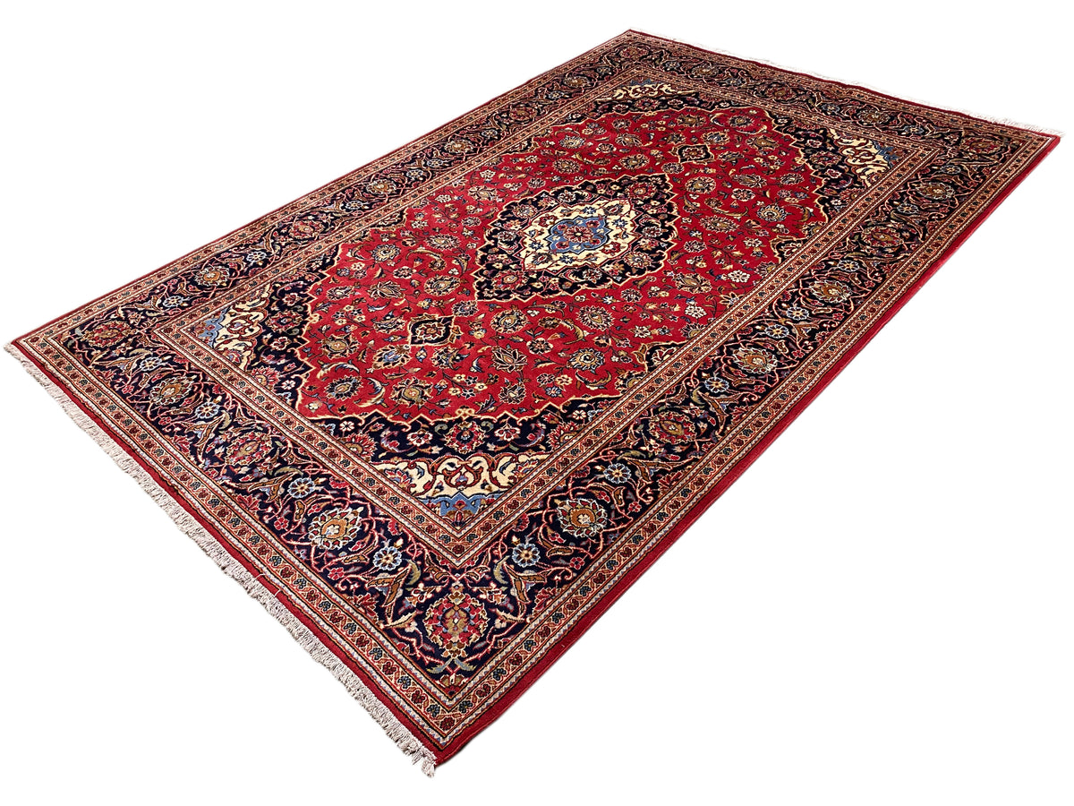 Rechteckiger Orientteppich mit rotem Muster, zentraler Rosette und dunkel abgesetztem Rand