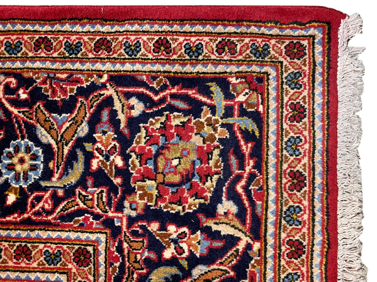 Detail am Teppichrand: rotes Ornamentfeld, mehrfarbige Bordüre und Fransen