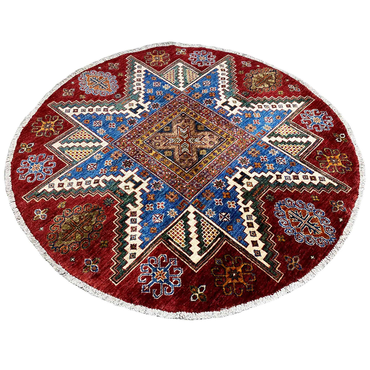 Runder Wollteppich mit blauem Mittelstern, rot-braunem Ornamentrahmen und weißer Einfassung