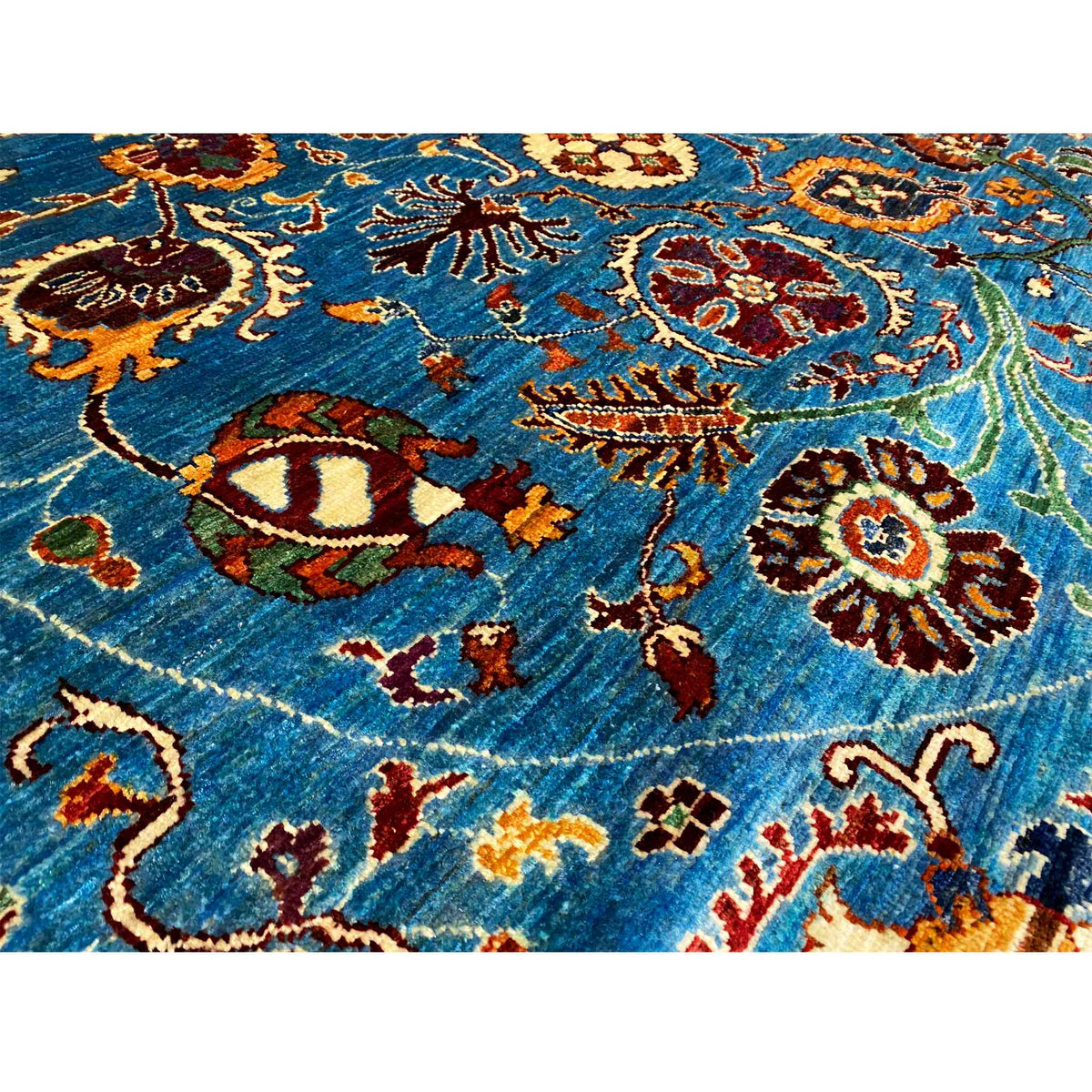 Rundteppich-Faserdetail: blaues Wollgewebe mit mehrfarbiger Stickerei