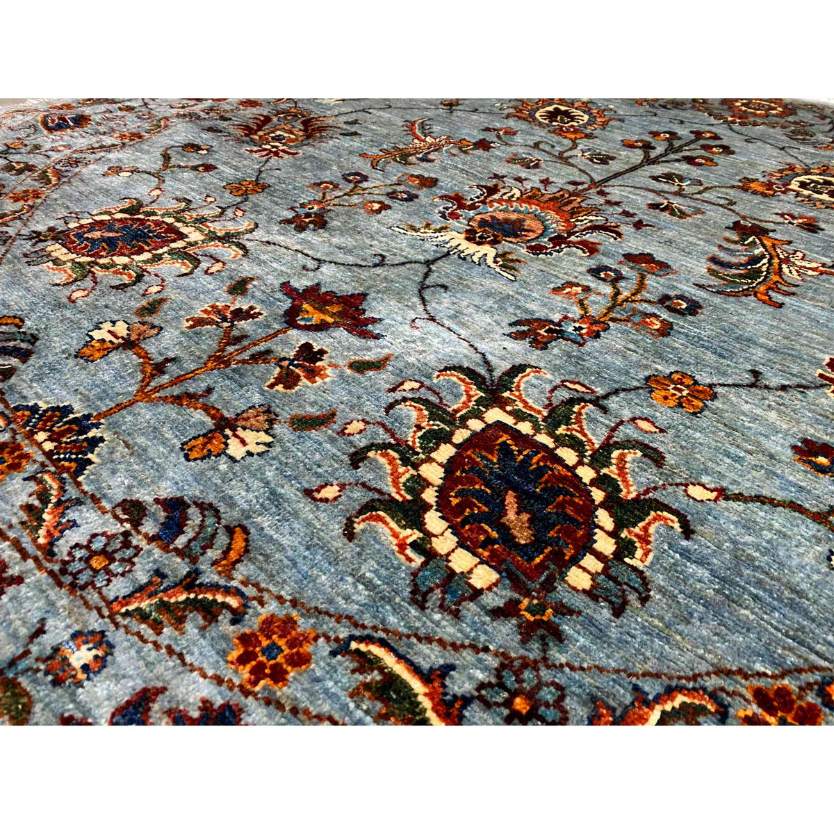 Handgeknüpfter Khorjin-Teppich Nahansicht: blau-graue Fläche mit rotem und goldenem Medaillon