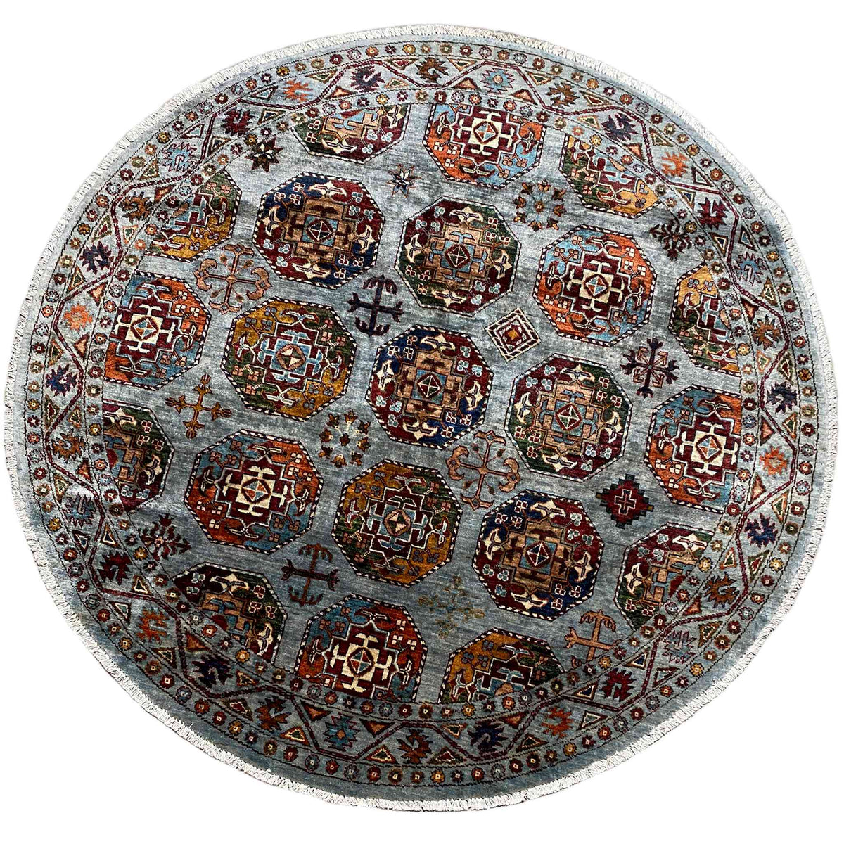 Runder Teppich mit mehrfarbigem Ornament-Muster auf hellem graublauem Grund