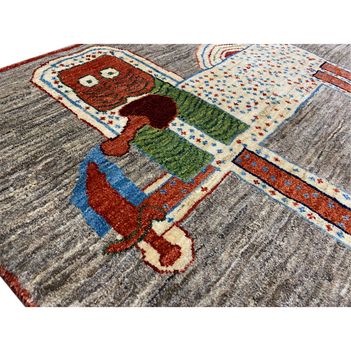Löwen-Gabbeh-Teppich 117x79 cm Detailansicht: farbiges Tiermotiv auf grauem Stoff