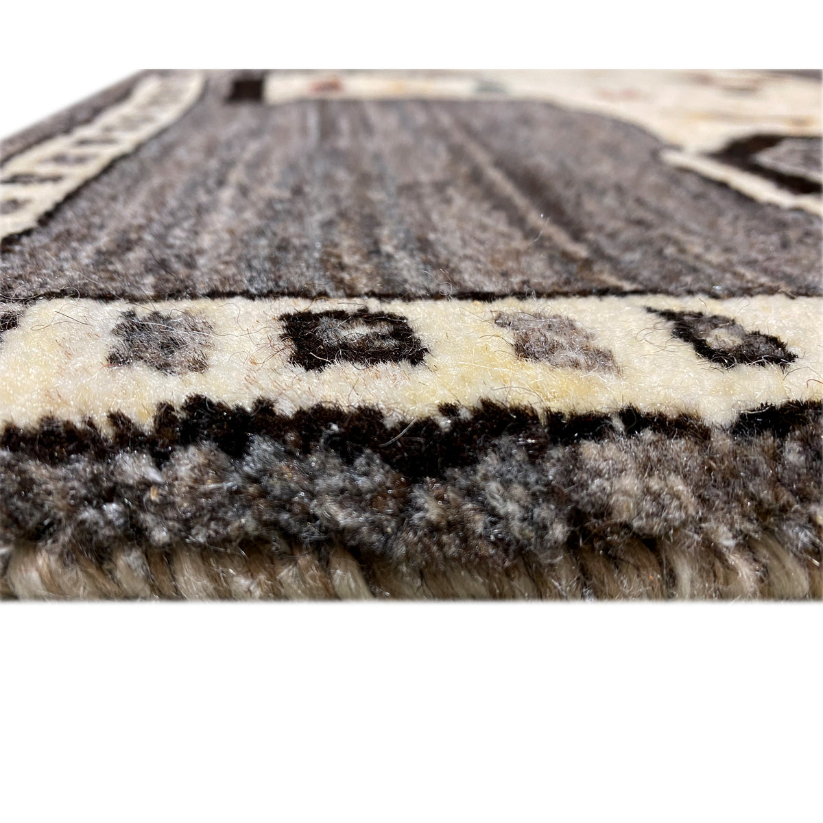 Teppichflor im Detail: graues und cremefarbenes Garn mit dichter, kurzer Struktur