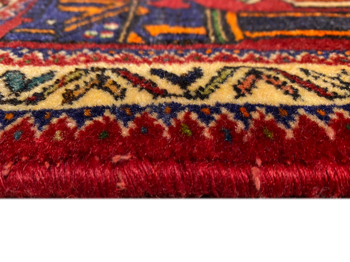 Poshti-Teppich 66x62 cm Detail der Kante: dichter roter Flor mit farbiger Bordüre.