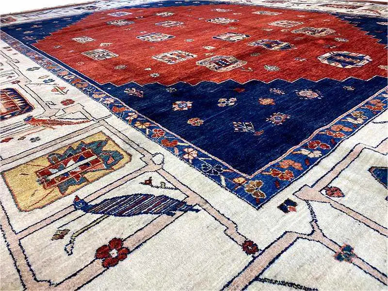 Orientteppich-Ecke mit rotem Innenfeld, dunkelblauem Rand und cremefarbenen Medaillons