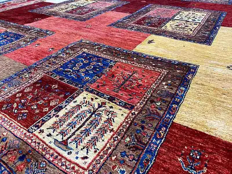 Detailansicht: Patchwork-Teppichflächen in Rot, Blau, Beige mit feinen Ornamenten