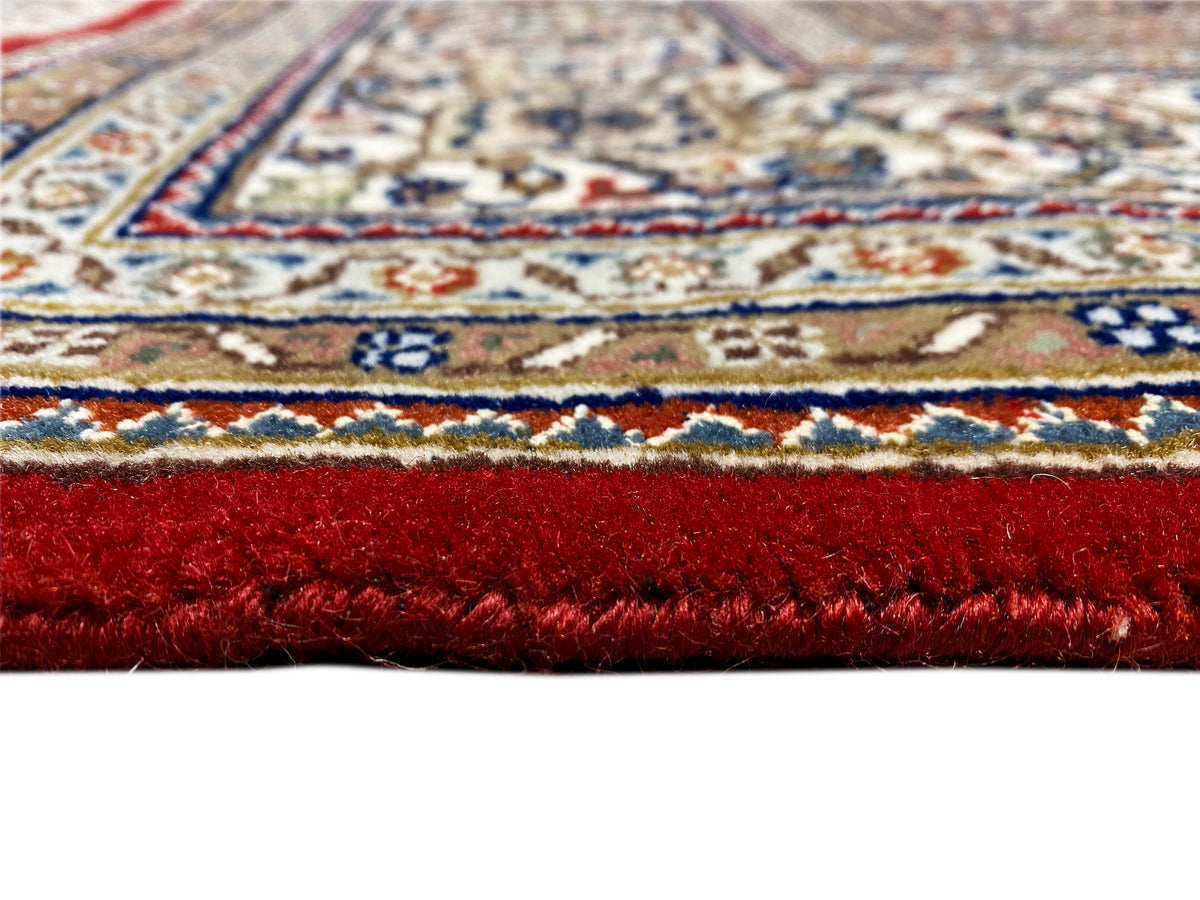 Teppich mit rotem Flor, mehrfarbigen Ornamenten und sichtbarer Musterkante