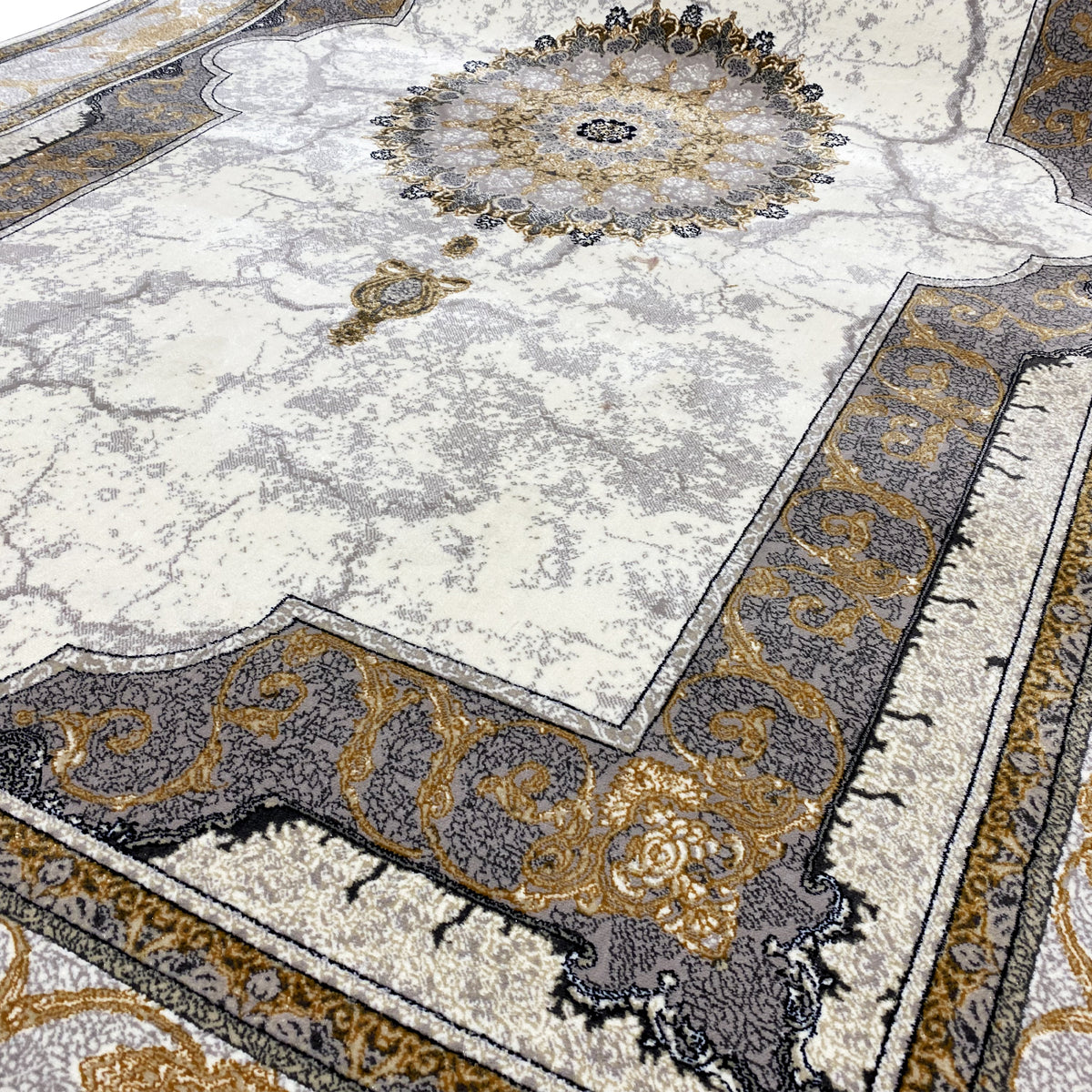 Teppichdetail: kreisförmiges Medaillon in Gold- und Dunkeltönen auf hellem Grund