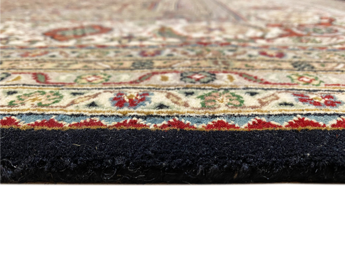 Nahansicht der Teppichkante mit dunklem Flor und buntem Bordürenstreifen