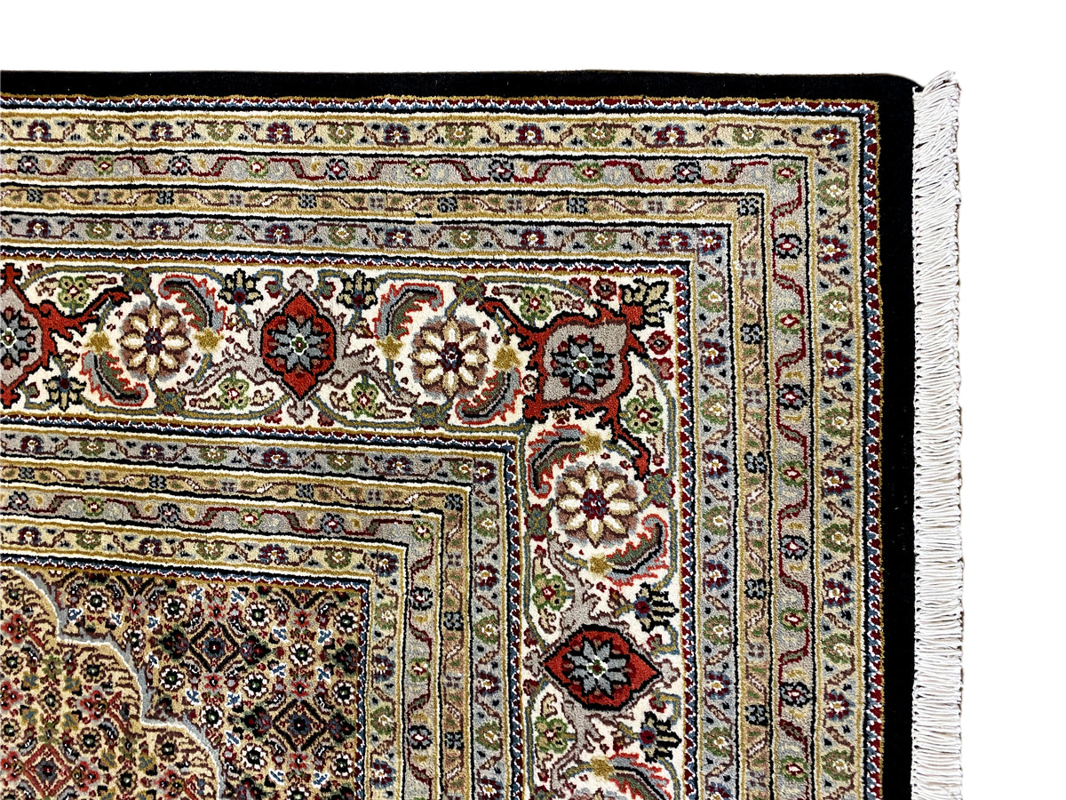 Teppichdetail mit mehrfarbigen Ornamentelementen und Fransen am Rand