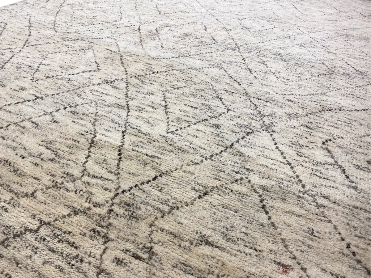 Nahaufnahme: hellbeiger Berber Teppich mit feinen dunkelgrauen Linien und Flechtdruck