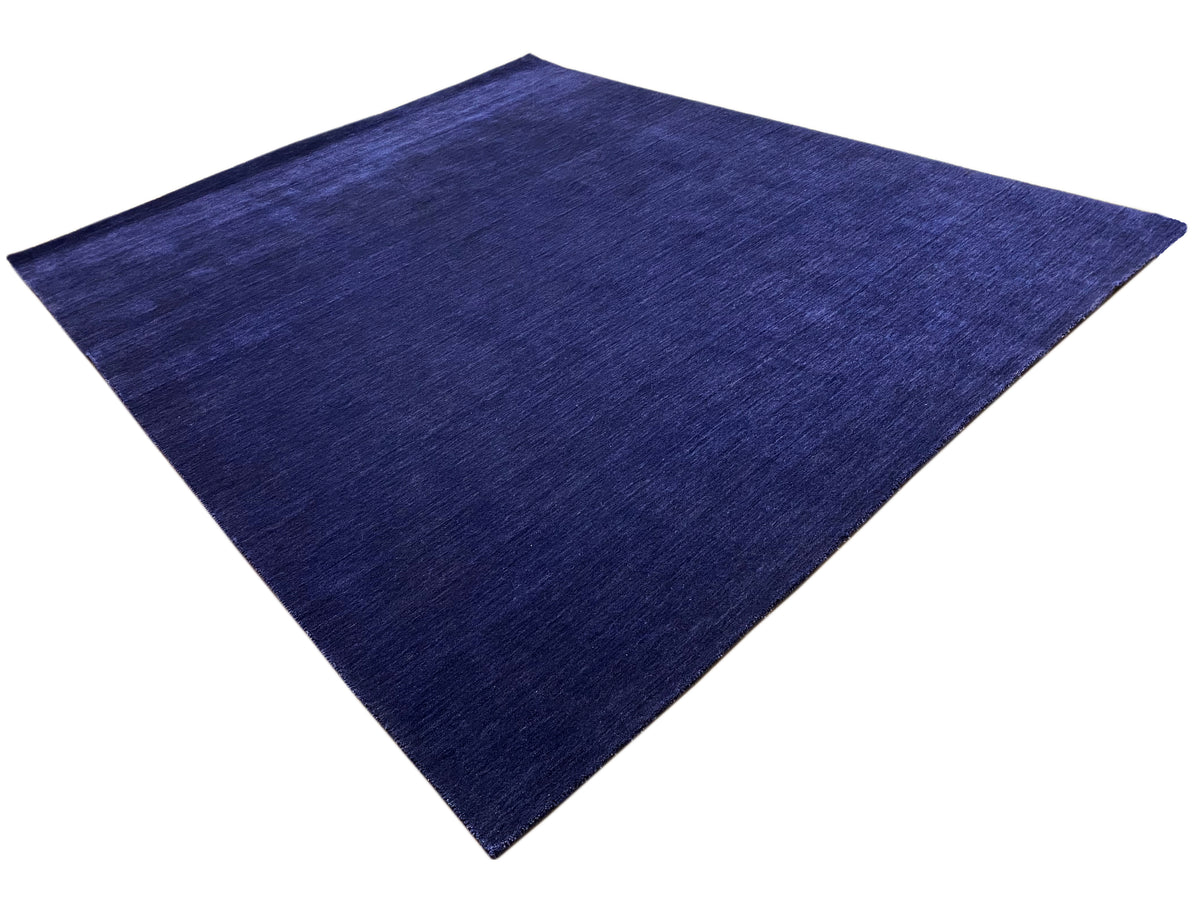 Blauer Teppich in Diamantansicht mit gleichmäßigem, fein gemasertem Flor.