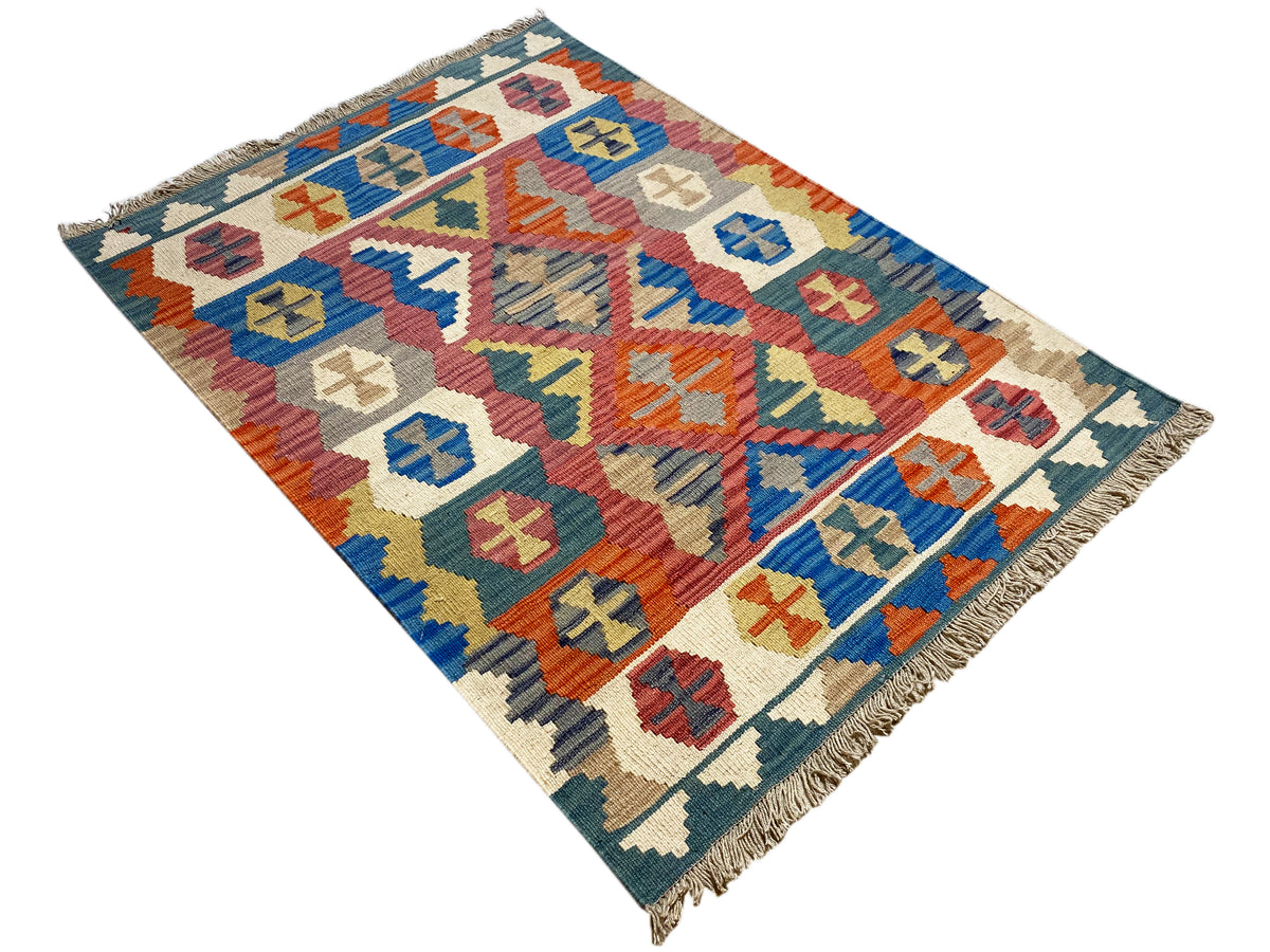 Qashqai-Kelimteppich diagonal gelegt: mehrfarbige Muster auf blauem Hintergrund
