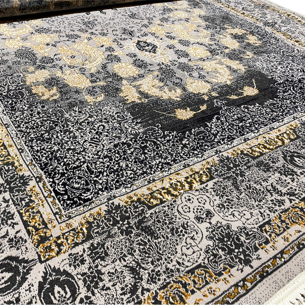 Teppich-Detail: dunkles Medaillon, florale Ornamente, goldene Akzente, Fransenrand