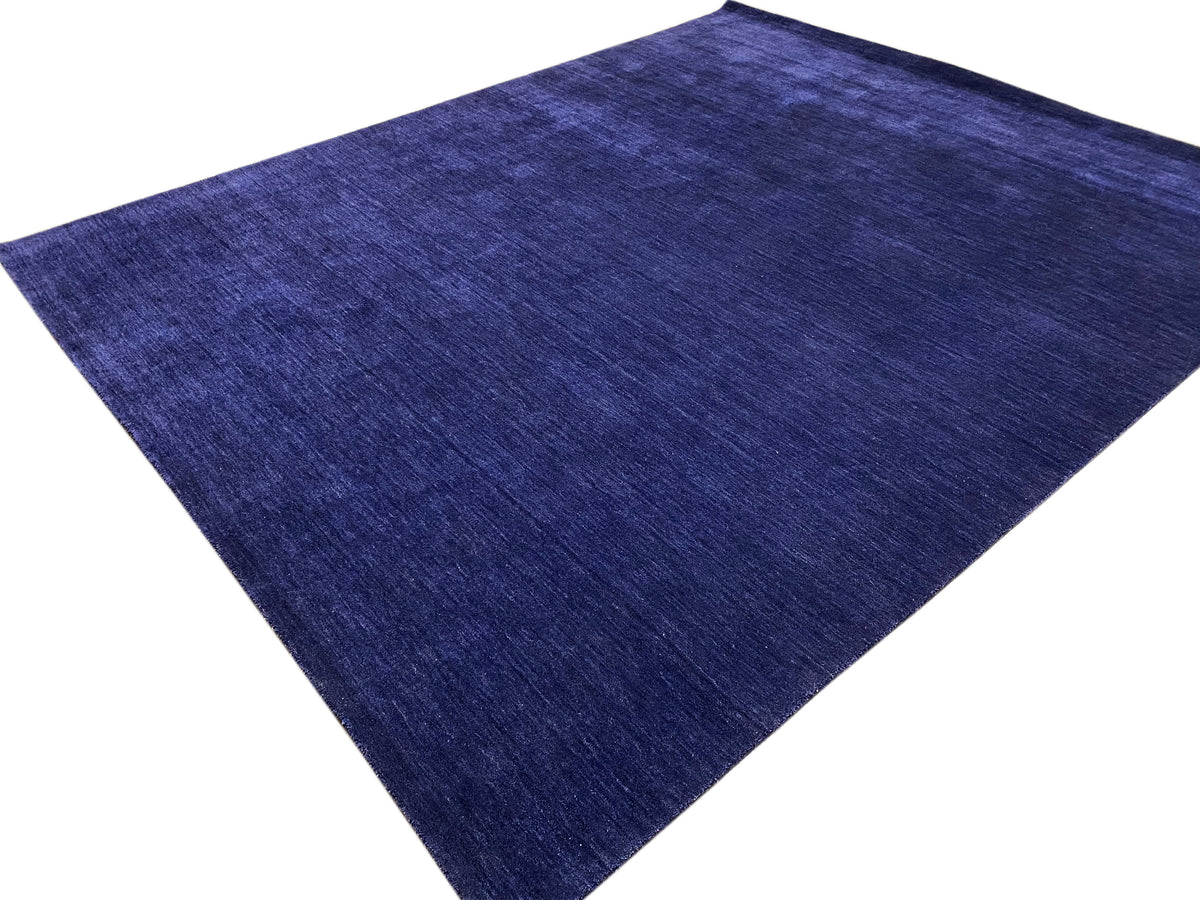 Blauer Teppich in schräger Ansicht mit feiner, gleichmäßiger Florstruktur.