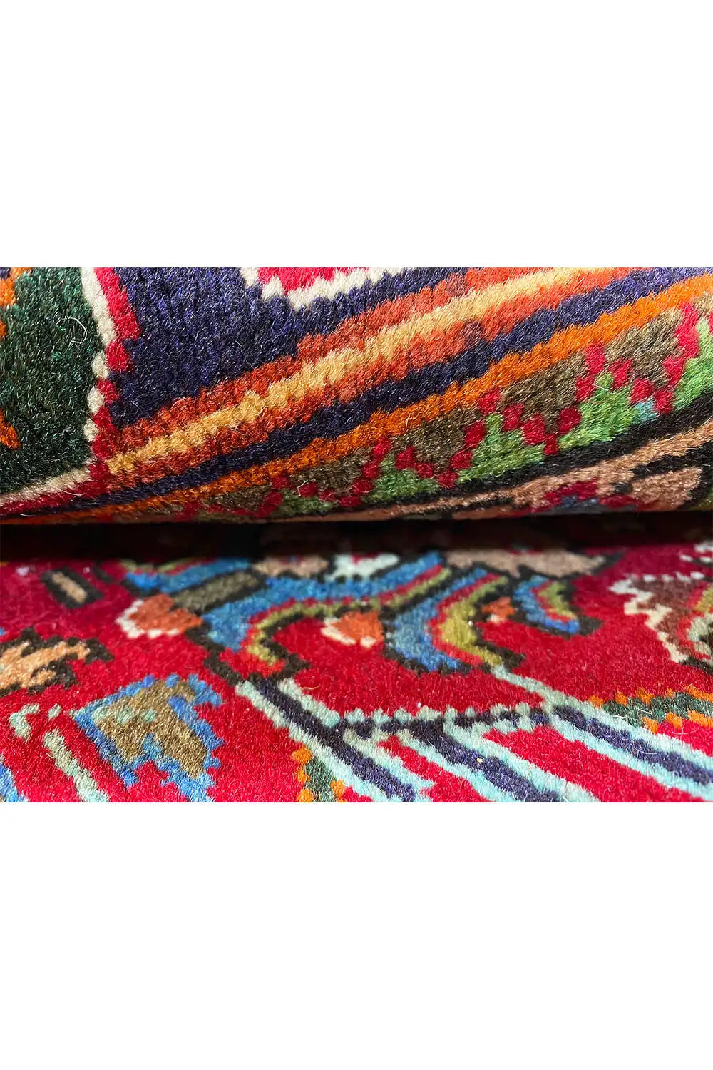 Nahaufnahme Teppichkante mit mehrfarbigem Ornamentmuster und dichtem Flor