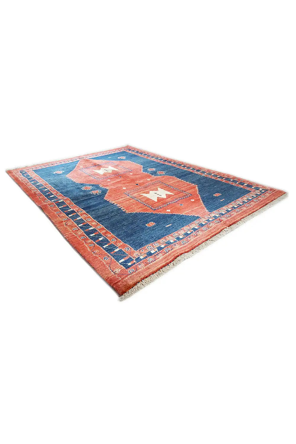 Teppich diagonal: blaues Feld mit orange-rotem Mittelmotiv und umlaufendem Musterrahmen
