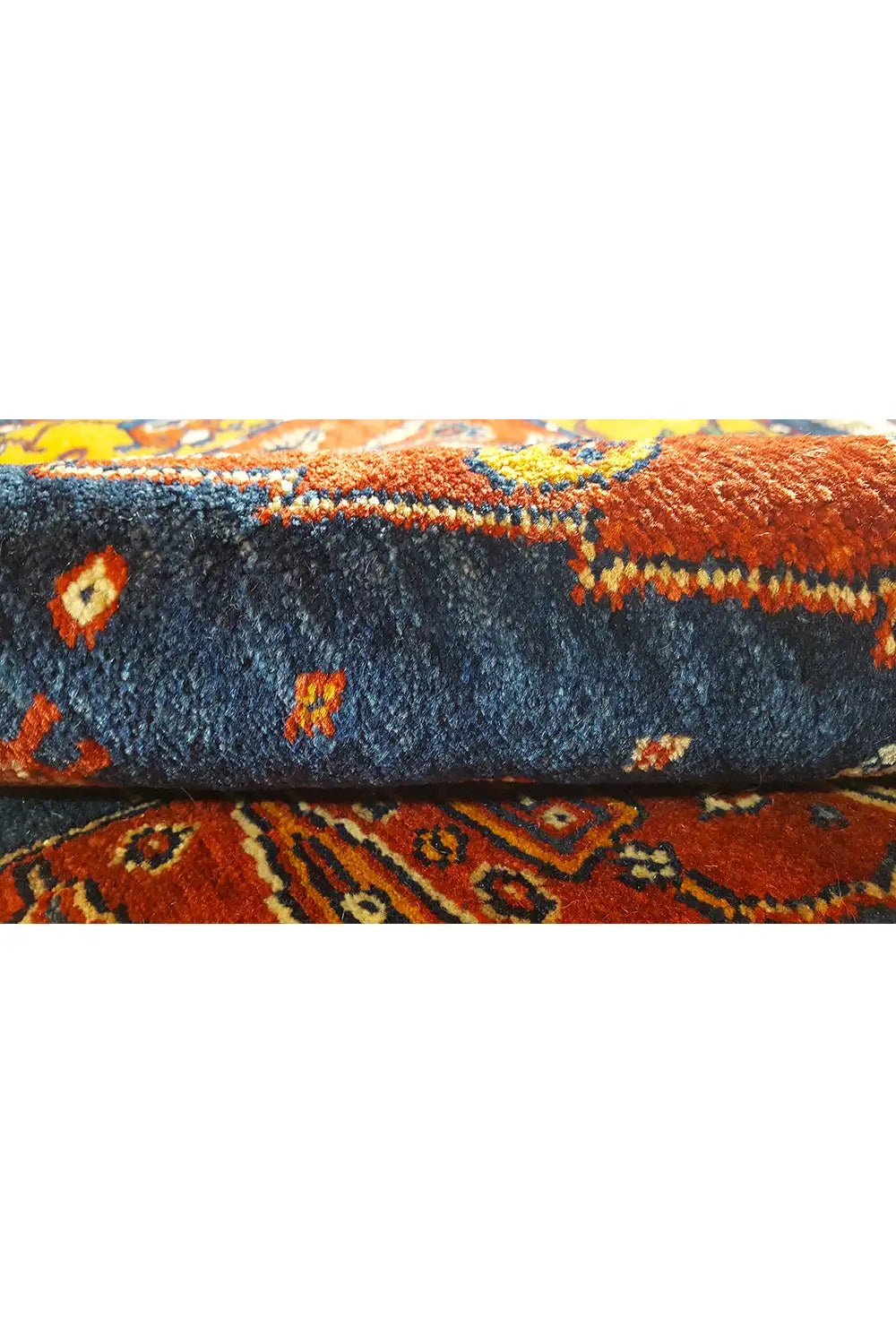 Gabbeh-Teppich Nahaufnahme: blauer Flor mit orangefarbenen Akzenten und Fransen.