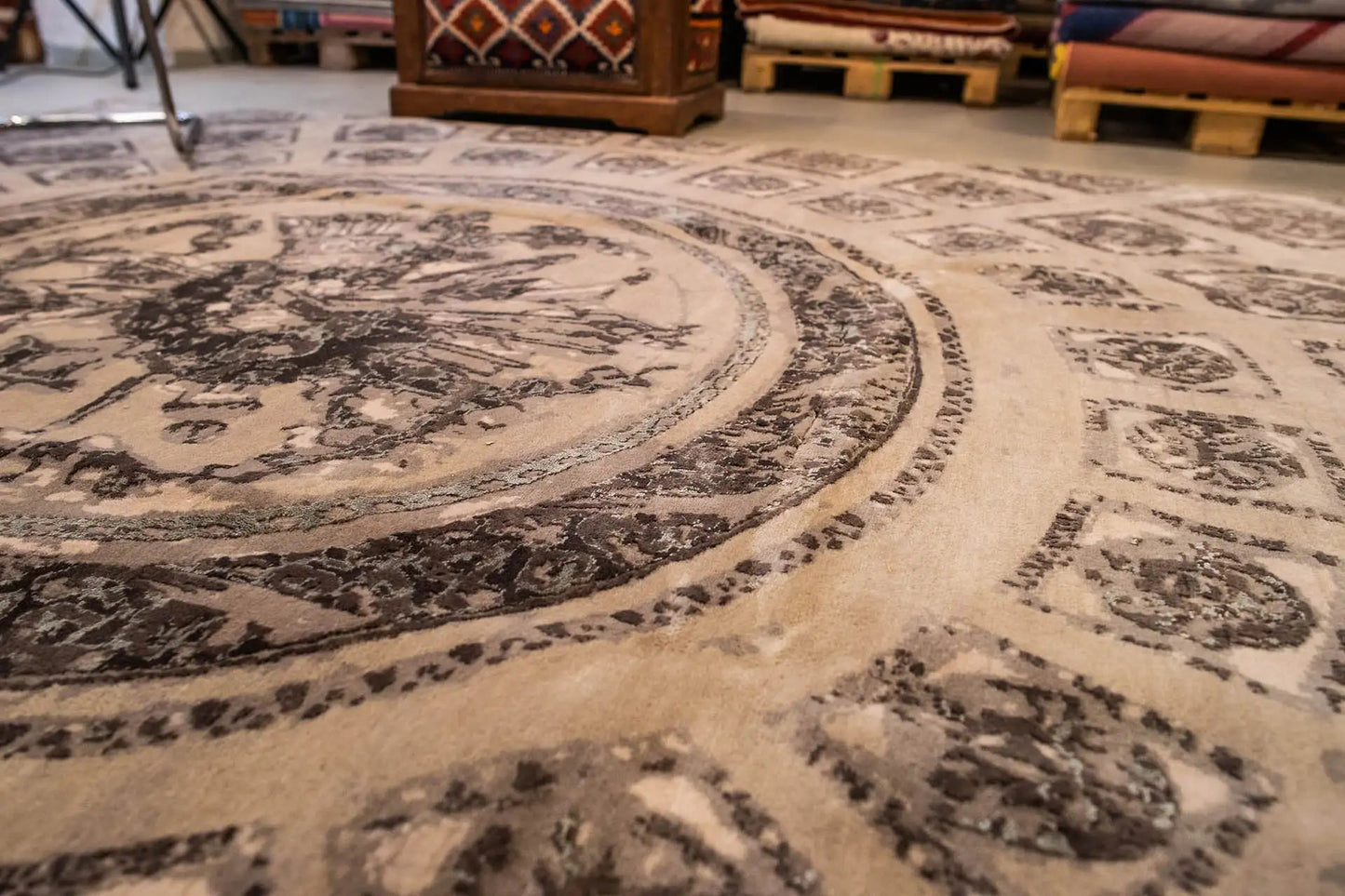 Nahaufnahme Teppich: zentrales Medaillon und Rahmenornamente in Beige/Dunkelgrau