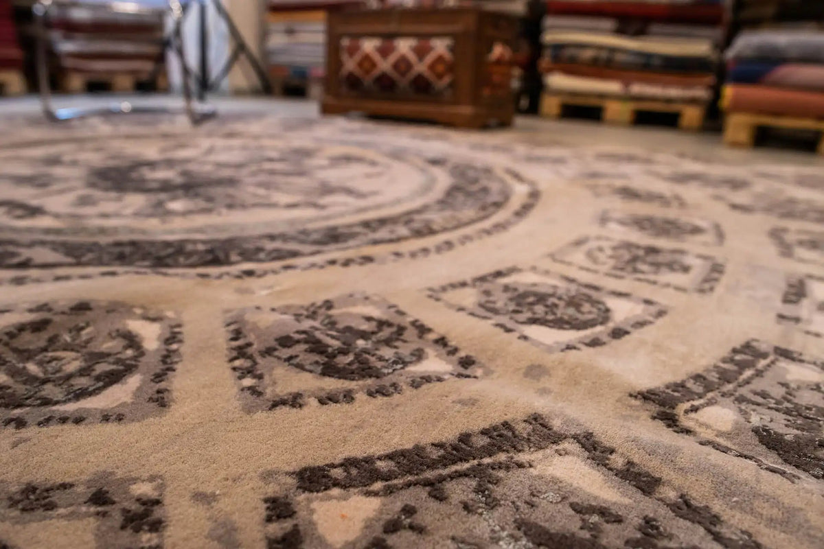Teppichmuster im Detail: wiederholte Ornamente und Bordüre in Beige und Grau