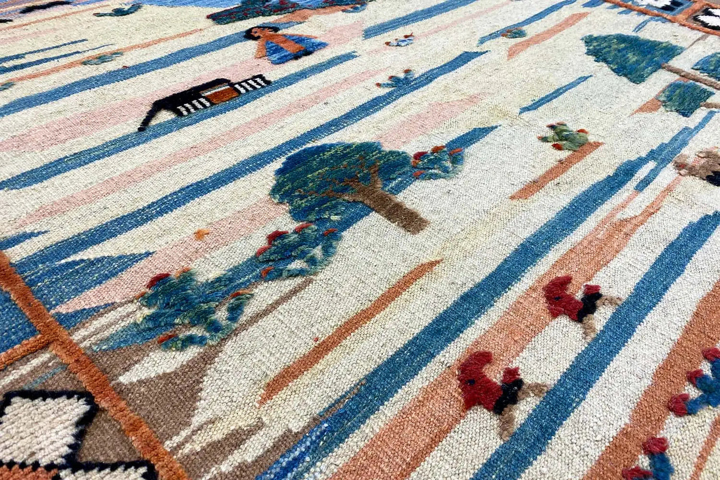 Detailansicht Kilim-Muster mit Figuren, Bäumen und blauem Streifenrahmen