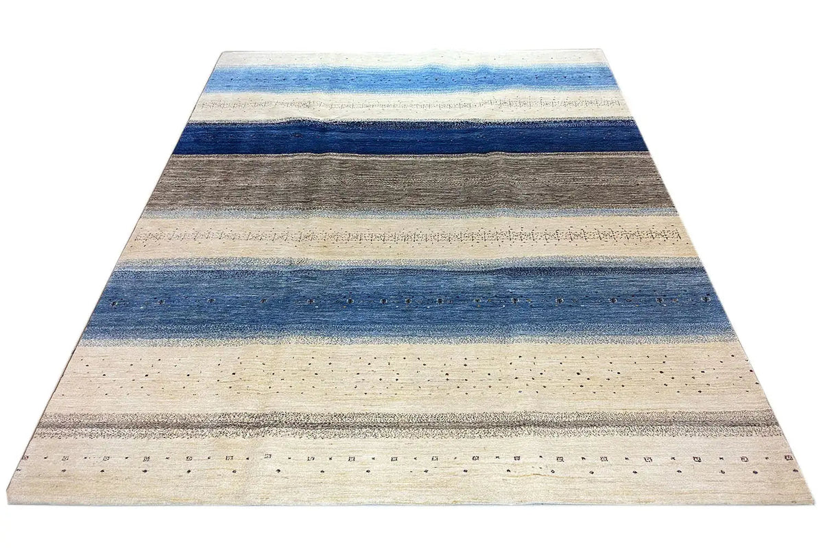 Gabbeh-Lori-Teppich: beige Fläche mit breiten Blau-Grau-Streifen und kleinen Punktmustern.