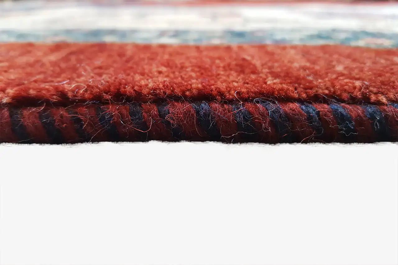 Orientteppich-Textur: dichter Flor mit roten und dunkelblauen Streifen an der Kante