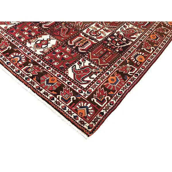 Bakhtiari-Teppich mit Eckansicht: bordeauxrotes Motivfeld, cremefarbene Ornamente und Bordüren