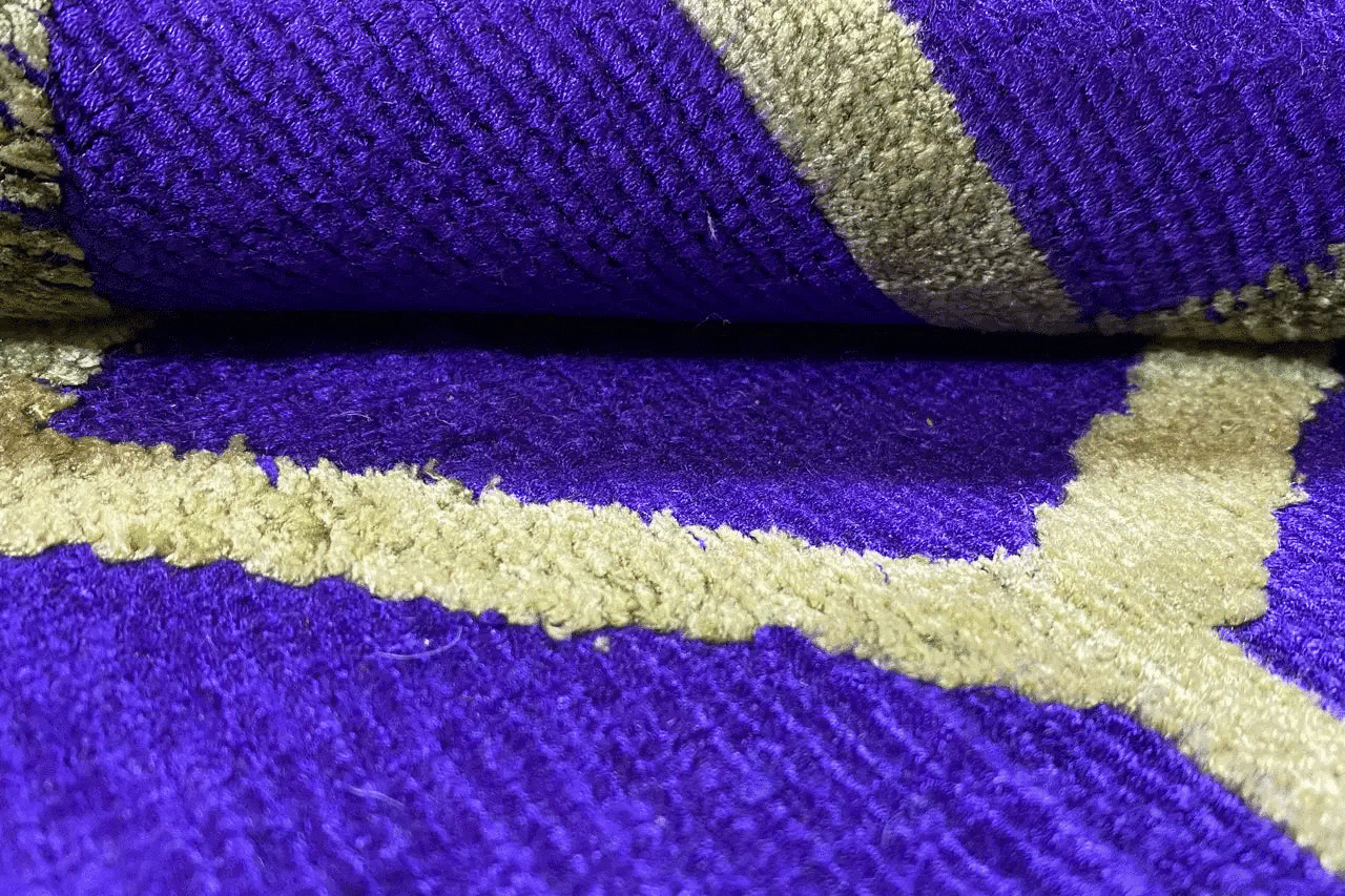 Teppich-Faser-Detail mit lila Oberfläche und gelbgrünen Kontrastlinien im Muster