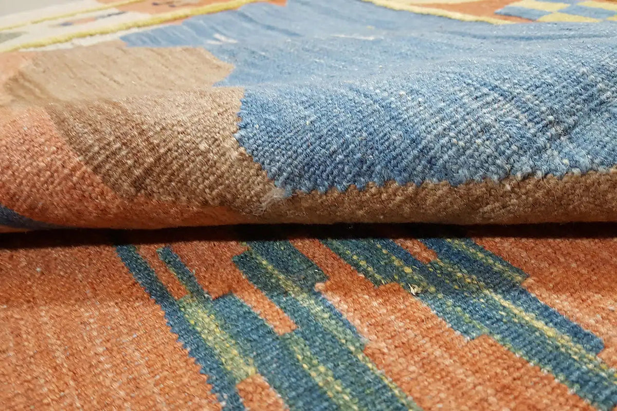 Kelimteppich-Detail mit blauem Flor und gewebten Mustern in Orange und Braun