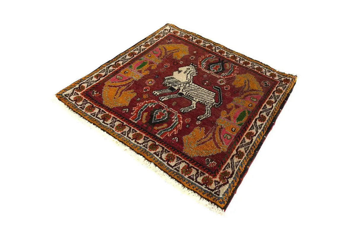Teppich mit rotem Musterfeld und weißem Pferd in Ornamenteinfassung