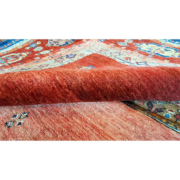 Nahansicht: Teppichflor mit roter, melierter Oberfläche und blau-roten Musterbereichen