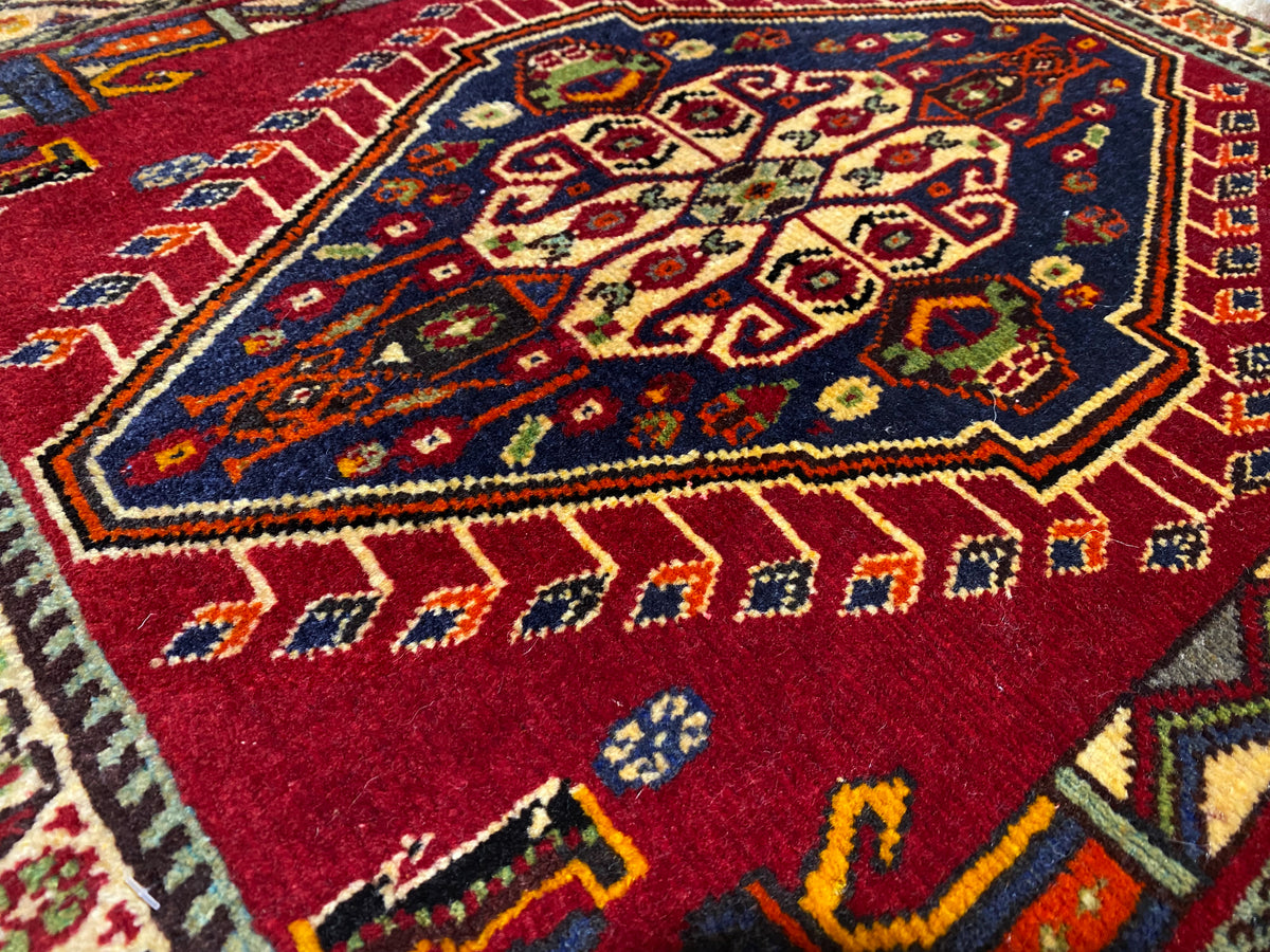 Nahaufnahme Poshti-Teppich (59×61 cm): rotes Innenmuster mit bunten Ornamenten und Rahmen