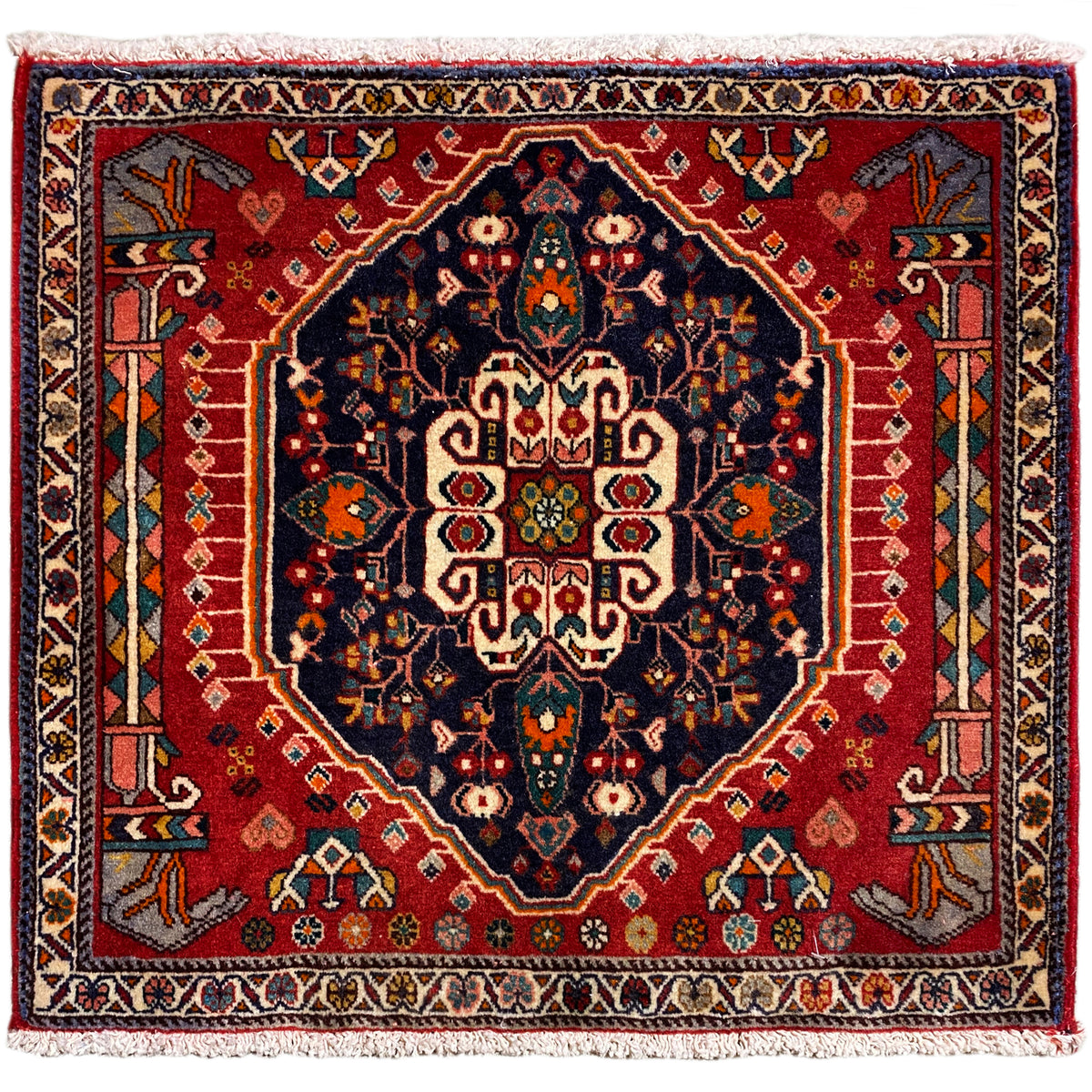 Quadratischer Teppich mit rotem Hintergrund und dunkelblauem Zentralmotiv, mit Fransen