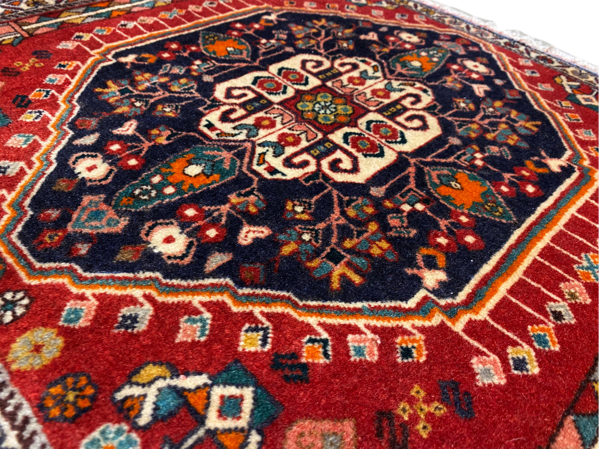 Teppich-Oberfläche: Mittelornament auf dunkelblauem Grund, farbige Bordüre, Fransenrand