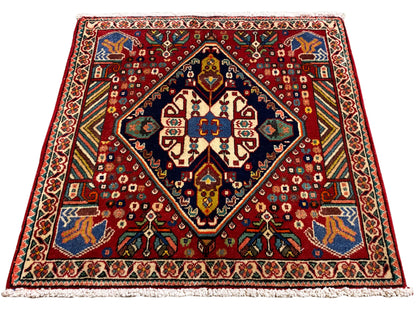 Teppich 66x62 cm mit rotem Muster, dunklem Rahmen und farbigen Ornamenten