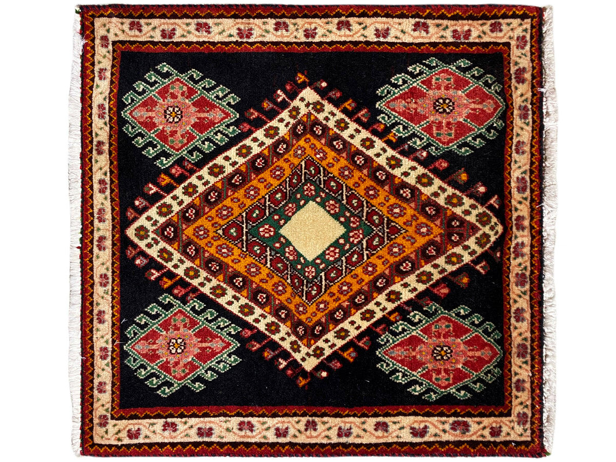 Poshti-Teppich mit schwarzem Hintergrund, orange-gelber Raute und vier grünen, roten Medaillons