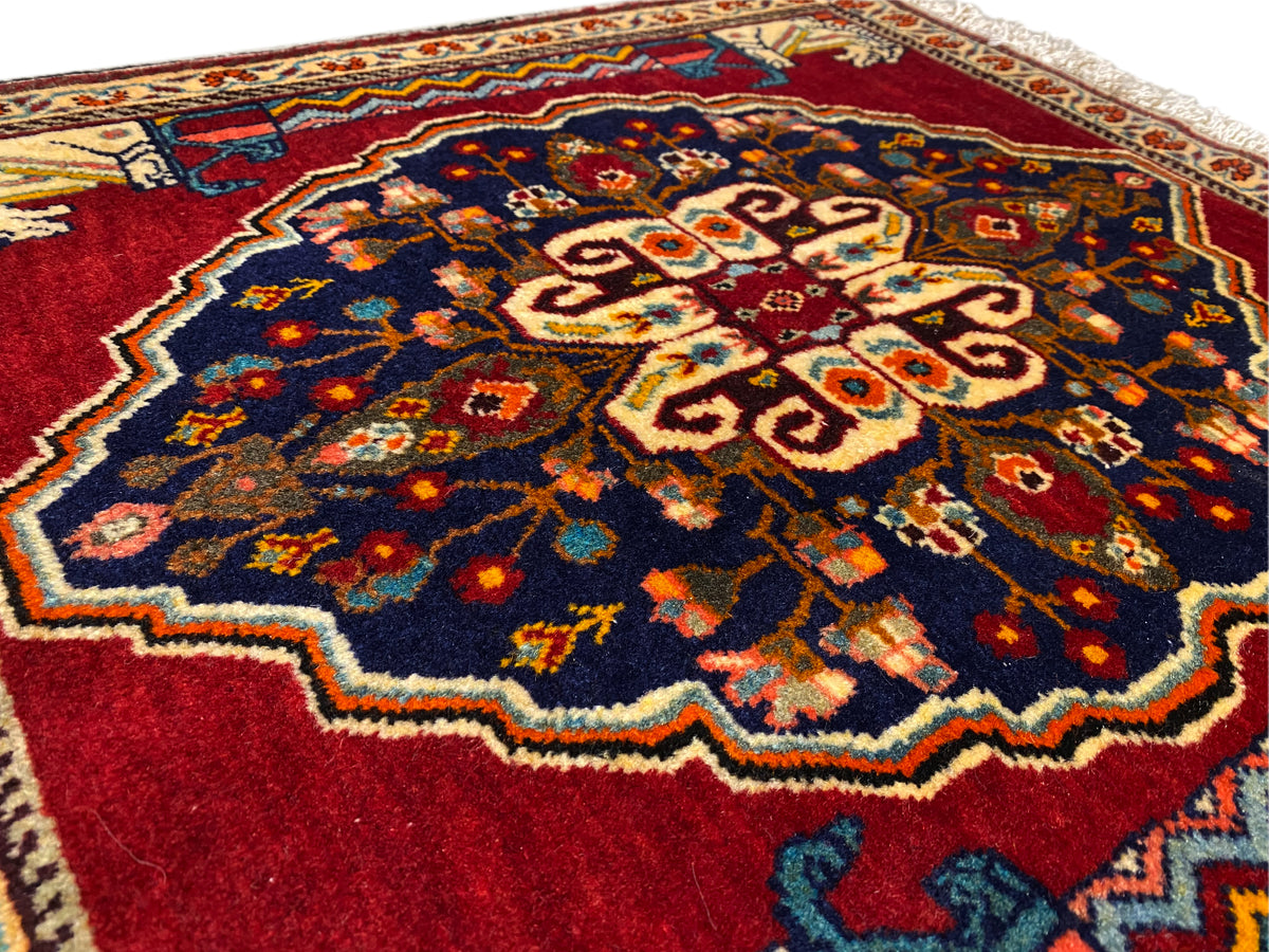 Nahaufnahme des Teppichzentrums: dunkelblau, Rot, Beige und mehrfarbige Ornamentflächen