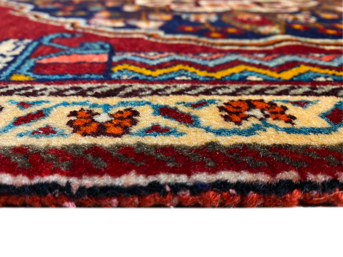 Teppich-Detail nah: farbige Bordüre, mehrfarbige Ornamente und dicke Florstruktur
