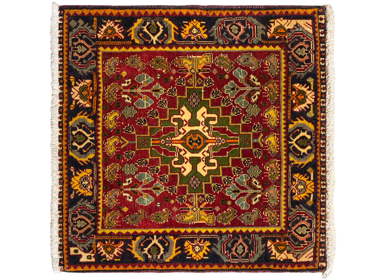 Teppich mit rotem Innenfeld, grün-gelben Ornamenten und dunklem Bordürenmuster