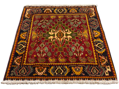 Teppich mit rotem Innenfeld, geometrischen Ornamenten und kurzer Fransenbordüre