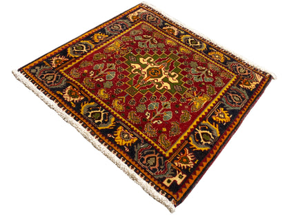 Teppich-Ecke mit rotem Muster, grünen Akzenten und dunklem Bordürenrahmen, Fransen